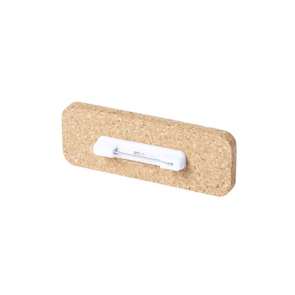 Identificador de línea nature fabricado en corcho natural, para así fomentar la utilización de materias primas naturales y reducir las emisiones contaminantes. Fijación de seguridad con imperdible en la parte trasera.