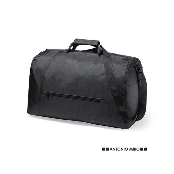 Bolso de Antonio Miró, fabricado en resistente poliéster 300D con acabados en negro. Compartimento principal y bolsillos exteriores con cierre de cremallera a juego  asas de transporte con velcro y bolsillos laterales. Con logotipo de la marca en la base y cinta bandolera ajustable.