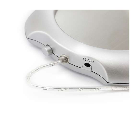 Calentador de tazas con conexión USB y de superficie metálica, especialmente diseñada para mantener el calor. De elegante diseño en color gris y compatible con tazas de hasta 7,4cm de diámetro, incorpora interruptor en la parte trasera y luces de estado. Presentada en caja individual.