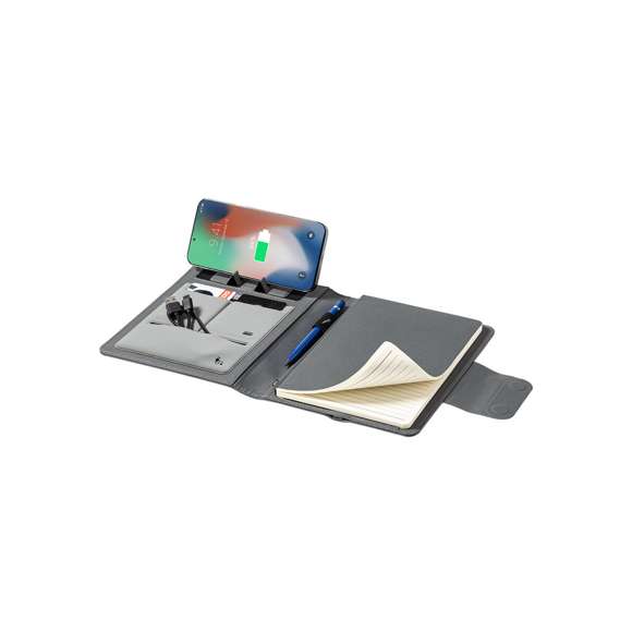 Carpeta/bloc multifunción fabricada en poliéster 300D RPET, elaborado a partir de plástico reciclado, para así fomentar la reutilización de residuos plásticos y ayudar a la sostenibilidad del planeta. Con cierre magnético y etiqueta interior con distintivo RPET.  Incluye cargador inalámbrico 10W integrado en portada, con fijación magnética para poder usar el dispositivo mientras se produce la carga del mismo e incluyendo anillo adhesivo, válido para todos los dispositivos con tecnología Magsafe y Qi.  Batería integrada de 5.000 mAh de capacidad de carga, con puerto Tipo C de entrada/salida y LEDs indicadores de estado de carga, con cable incluido.  Interior con soporte para smartphone y multitud de compartimentos para tarjetas, incluidos soporte para bolígrafo y bloc A5 con 65 hojas de disposición a una raya.  Presentada en atractiva caja individual de diseño.  Las capacidades mostradas en todas nuestras baterías auxiliares externas son reales, incorporando todas ellas baterías de grado A y no recicladas, con una vida útil de al menos 500 ciclos de carga y según normativa CE. Además, están fabricadas conforme a los estándares RoHS y en cumplimiento con los siguientes requisitos de seguridad:  Sistema de protección contra sobrecarga del power bank. Sistema de protección contra descarga completa que proporciona una mayor durabilidad del power bank. Sistema de bloqueo para evitar cortocircuitos. Sistema de transferencia de carga constante, acorde con la capacidad del dispositivo de destino.