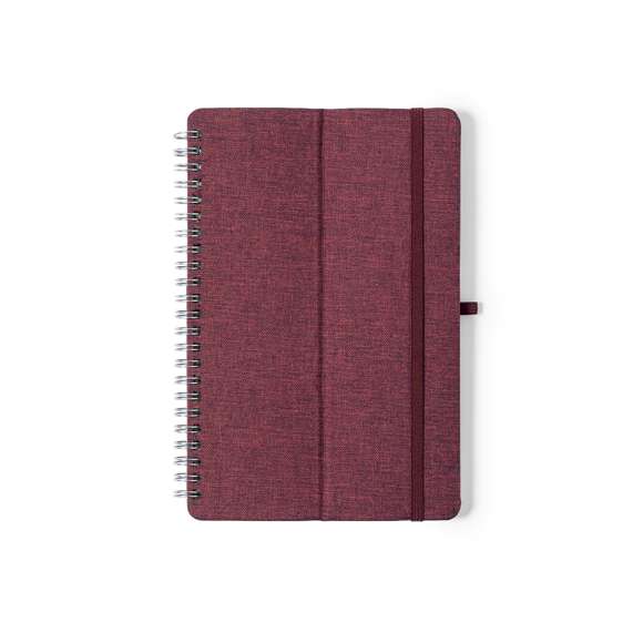  	Libreta soporte de anillas de línea nature. Tapas rígidas fabricadas en resistente material RPET 300D, elaborado a partir de plástico reciclado. Con original soporte para smartphone y tablet integrado en la portada y fabricado en caña de trigo. Incluye elástico de cierre y soporte para bolígrafo a juego. 70 hojas interiores con disposición a una raya y disponible en variada gama de colores. Con distintivo RPET en contraportada y presentada en bolsa individual reciclada.