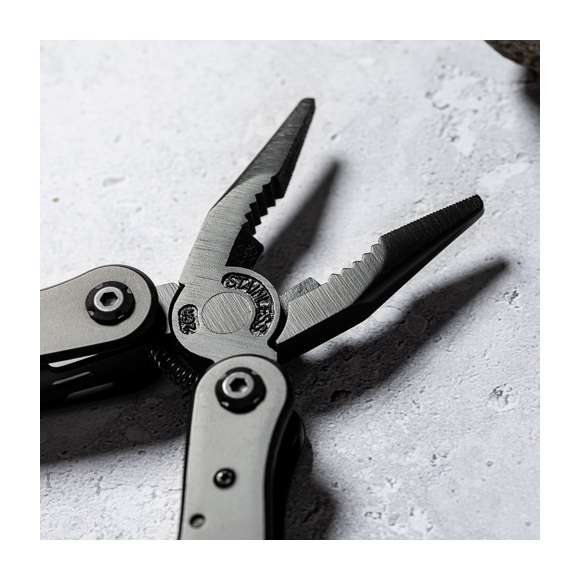 Multiherramienta con accesorios en acero inox de acabado negro y resistente empuñadura a juego en aluminio. Con 13 funciones, entre ellas cuchillo y navaja  destornillador, lima  abridor y alicates. Plegable y de tamaño compacto, presentada en caja individual de diseño negra.