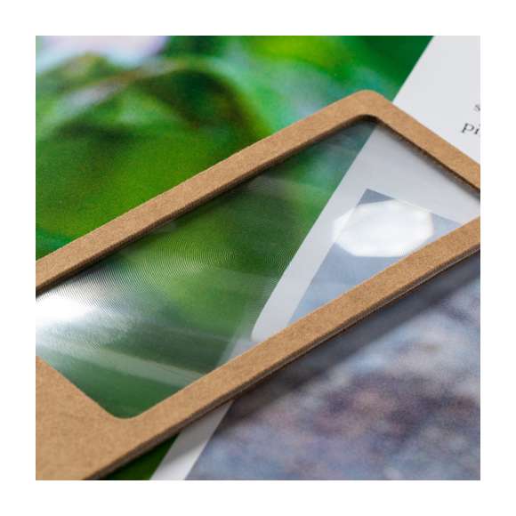 Marcapáginas de línea nature con lupa 3X integrada. Fabricado en cartón reciclado, con amplia superficie de marcaje y con cordón de transporte a juego.