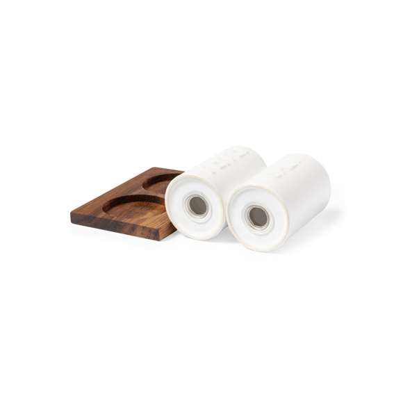  	Set de salero y pimentero en blanco y fabricados en cerámica. Incluye base en madera natural de acacia, troquelada para encajar el salero y el pimentero. Presentación en caja individual de diseño kraft.