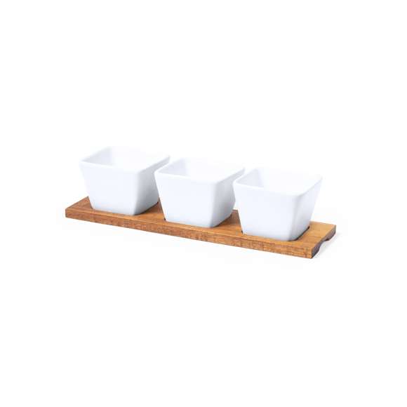 Bandeja de entremeses con 3 cuencos en blanco y fabricados en cerámica. Incluye base en madera natural, troquelada para encajar los cuencos. Presentación en caja individual de diseño kraft.