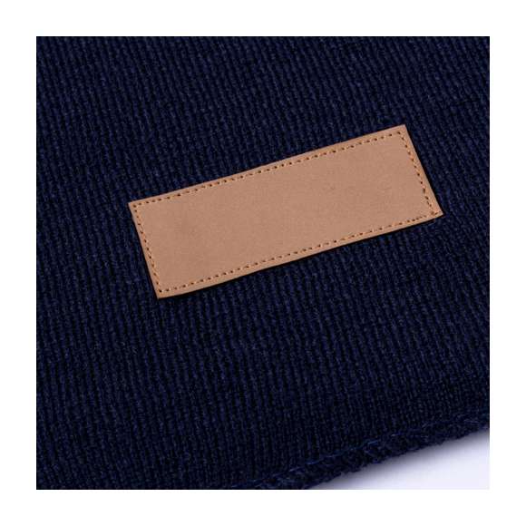 Bufanda unisex fabricada en material acrílico elástico. Con parche en polipiel cosido para marcaje y disponible en variada gama de colores.