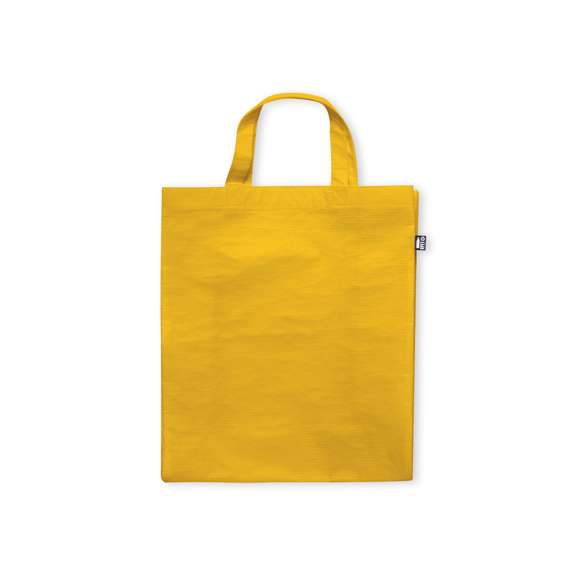 Bolsa de línea nature fabricada RPET laminado de 110g/m2. De acabado cosido, con fuelle y asas cortas reforzadas (35 x 2,5cm). Disponible en variada gama de colores, con distintivo RPET en etiqueta exterior. Resistencia hasta 5 kg de peso.El material RPET se elabora a partir de plástico reciclado, para así fomentar la reutilización de residuos plásticos y ayudar a la sostenibilidad del planeta.