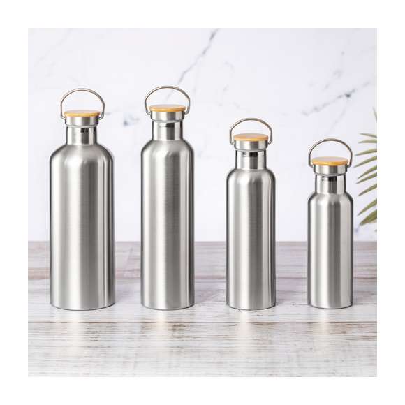 Bidón térmico de 500 ml de capacidad, fabricado en acero inox de doble pared y acabado mate. Incluye original tapón a rosca en acero inox, con detalle de bambú y asa integrada. Libre de BPA y presentado en caja individual de diseño kraft.