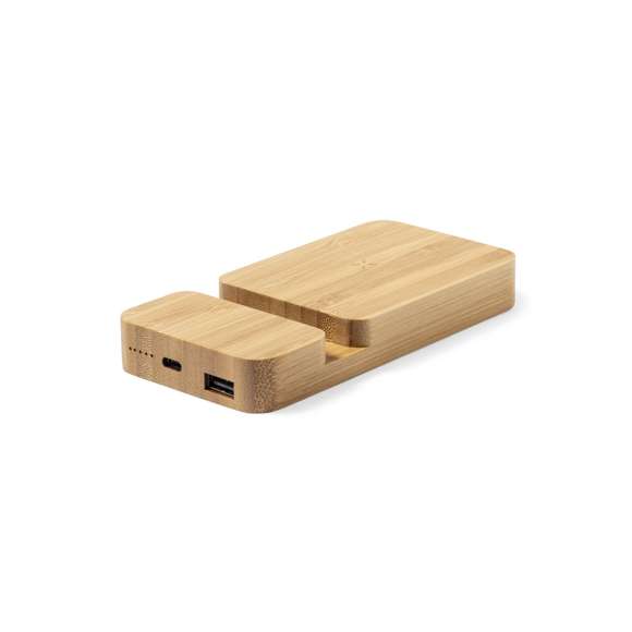Batería auxiliar externa de 5.000 mAh fabricada en bambú, con cargador inalámbrico integrado 15W y soporte para dispositivo móvil.Salida USB, con conexión Tipo C dual de entrada y salida e indicador LED de estado de carga. Compatible con dispositivos equipados con tecnología de carga inalámbrica Qi, cable de carga Tipo C incluido. Presentado en caja individual de diseño kraft, con manual de instrucciones en español e inglés. Entrada/Salida USB C: 5-12V DC 3-1.67V, PD20WSalida USB: 5-12V DC 3-1.5ALas capacidades mostradas en todas nuestras baterías auxiliares externas son reales, incorporando todas ellas baterías de grado A y no recicladas, con una vida útil de al menos 500 ciclos de carga y según normativa CE. Además, están fabricadas conforme a los estándares RoHS y en cumplimiento con los siguientes requisitos de seguridad:Sistema de protección contra sobrecarga del power bank. Sistema de protección contra descarga completa que proporciona una mayor durabilidad del power bank. Sistema de bloqueo para evitar cortocircuitos. Sistema de transferencia de carga constante, acorde con la capacidad del dispositivo de destino.