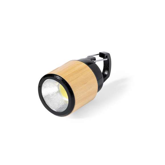 Linterna fabricada en bambú con mosquetón de transporte en resistente ABS negro. 3 LEDs, sistema de encendido de botón y alimentación a pilas (de botón incluidas). Presentada en caja individual de diseño kraft.Materiales como el bambú fomentan la utilización de materias primas naturales reduciendo las emisiones contaminantes. Además, el bambú proviene de una planta de gran resistencia y versatilidad, con crecimiento y regeneración rápida, siendo una excelente alternativa al uso de madera tradicional.