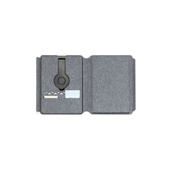Carpeta/bloc multifunción con cierre magnético fabricada en poliéster 300D RPET, elaborado a partir de plástico reciclado, y etiqueta interior con distintivo RPET.Cargador inalámbrico de 10W, con fijación magnética y multiposición, integrado en portada, que permite usar el dispositivo mientras se está cargando. Accesorio anillo adhesivo incluido, compatible con todos los dispositivos equipados con tecnología Magsafe y Qi. Con cargador inalámbrico para smartwatch en la contraportada interior.Batería integrada de 5.000 mAh de capacidad de carga, con puerto Tipo C de entrada/salida y LEDs indicadores de estado de carga, con cable cargador incluido.Interior con soporte para smartphone y multitud de compartimentos para tarjetas. Soporte para bolígrafo y bloc interior A5 de 64 hojas, con disposición a una raya.Presentada en atractiva caja individual de diseño.Las capacidades mostradas en todas nuestras baterías auxiliares externas son reales, incorporando todas ellas baterías de grado A y no recicladas, con una vida útil de al menos 500 ciclos de carga y según normativa CE. Además, están fabricadas conforme a los estándares RoHS y en cumplimiento con los siguientes requisitos de seguridad:Sistema de protección contra sobrecarga del power bank.Sistema de protección contra descarga completa que proporciona una mayor durabilidad del power bank.Sistema de bloqueo para evitar cortocircuitos.Sistema de transferencia de carga constante, acorde con la capacidad del dispositivo de destino.