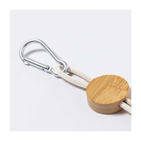 Cable cargador con mosquetón de transporte. Fabricado usando materiales naturales y respetuosos con el medio ambiente:Pieza central en bambú natural.Cables recubiertos de algodón, incluyen conexiones de entrada Tipo C y USB, salidas Lightning, Micro USB y Tipo C. 5V DC 2.4A.Presentado en bolsa individual de diseño kraft. Poner que lleva distintivo en hangtag de bambú y algodón kraft.Elaborado con elementos vegetales para así fomentar la utilización de materias primas naturales y reducir las emisiones contaminantes.