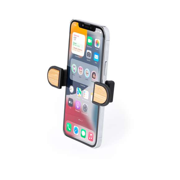 Soporte ajustable para smartphone de diseño minimalista, con base rotatoria 360º y de elegante acabado en color negro con detalles en bambú. Con sistema de fijación en rejilla de ventilación del automóvil y amplia superficie de marcaje, diseñado especialmente para tampografía. Presentado en caja de diseño kraft. Materiales como el bambú fomentan la utilización de materias primas naturales, reduciendo las emisiones contaminantes. Proviene de una planta de gran resistencia y versatilidad, con crecimiento y regeneración rápidos, siendo una excelente alternativa al uso de madera tradicional.