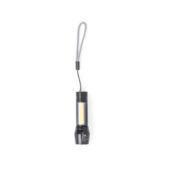 Potente linterna con batería recargable, fabricada en aluminio de acabado en color negro. Luz frontal con 1 LED y cabezal regulable, para tener un enfoque más focalizado o abierto. Además, cuenta con 10 luces COB en el mango y tres modos de iluminación (fija e intermitente de dos velocidades), incluye cinta de trasporte. Se alimenta mediante una batería recargable de 400 mAh, incluido cable micro USB. Presentada individualmente en caja de diseño.