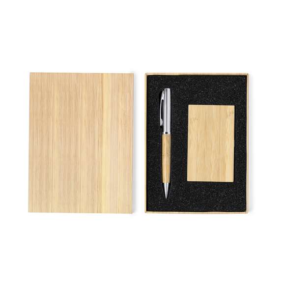 Distinguido set de bolígrafo y tarjetero fabricados en bambú y metal. Práctico conjunto de bolígrafo con cuerpo metálico brillante y empuñadura de suave bambú con mecanismo giratorio y en tinta azul. Incluye excelente tarjetero de un compartimento en brillante metal, con tapa en suave bambú. Presentado en una caja individual diseño bambú.Materiales como el bambú fomentan la utilización de materias primas naturales, reduciendo las emisiones contaminantes. Proviene de una planta de gran resistencia y versatilidad, con crecimiento y regeneración rápidos, siendo una excelente alternativa al uso de madera tradicional.