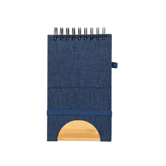 Libreta de anillas con soporte elaborado en RPET 300D y bambú. Sus tapas rígidas destacan por un versátil soporte integrado para smartphone, fabricado en bambú. Además, cuenta con elástico de cierre y soporte para bolígrafo a juego. Contiene 80 hojas interiores lisas y está disponible en una variada gama de colores. Con logotipo RPET en contraportada y presentada en bolsa individual reciclada.El material RPET se elabora a partir de plástico reciclado, para así fomentar la reutilización de residuos plásticos y ayudar a la sostenibilidad del planeta.