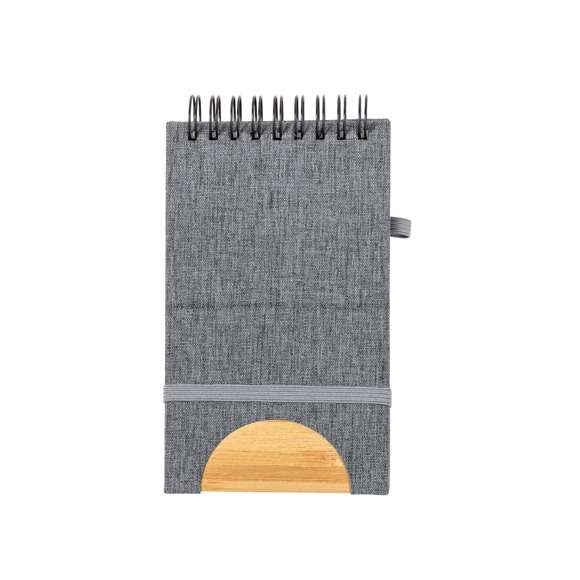 Libreta de anillas con soporte elaborado en RPET 300D y bambú. Sus tapas rígidas destacan por un versátil soporte integrado para smartphone, fabricado en bambú. Además, cuenta con elástico de cierre y soporte para bolígrafo a juego. Contiene 80 hojas interiores lisas y está disponible en una variada gama de colores. Con logotipo RPET en contraportada y presentada en bolsa individual reciclada.El material RPET se elabora a partir de plástico reciclado, para así fomentar la reutilización de residuos plásticos y ayudar a la sostenibilidad del planeta.