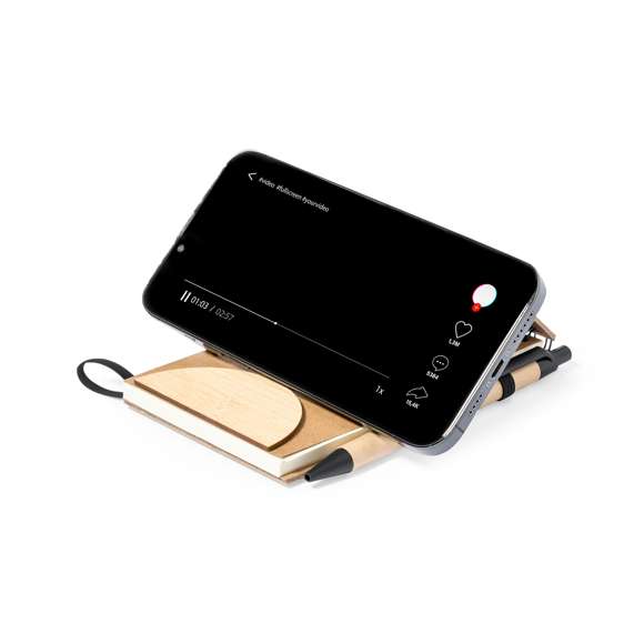 Libreta de anillas fabricada en corcho y bambú. De tapas rígidas, con un versátil soporte integrado para smartphone fabricado en bambú. Además, cuenta con elástico de cierre y soporte para bolígrafo a juego. Contiene 80 hojas internas de disposición a una raya. Presentada en bolsa individual reciclada.Elaborado con elementos vegetales para así fomentar la utilización de materias primas naturales y reducir las emisiones contaminantes.