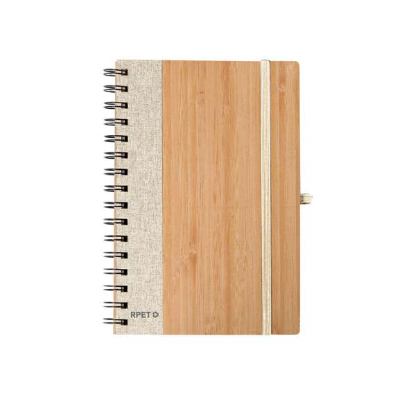 Libreta de anillas con tapas rígidas de bambú. Incluye 80 hojas con disposición a una raya de papel reciclado. Con cierre elástico, banda lateral, y soporte para bolígrafo a juego. Disponible en variada gama de colores, presentada individualmente en bolsa de papel reciclado. Materiales como el bambú fomentan la utilización de materias primas naturales, reduciendo las emisiones contaminantes. Proviene de una planta de gran resistencia y versatilidad, con crecimiento y regeneración rápidos, siendo una excelente alternativa al uso de madera tradicional.