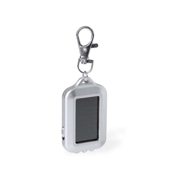 Práctico llavero linterna con carga solar, equipado con 3 luces LEDs y un botón lateral de encendido y apagado. Se recarga fácilmente gracias a su placa solar. Con gancho metálico giratorio para un cómodo transporte. Presentado en caja de diseño kraft.