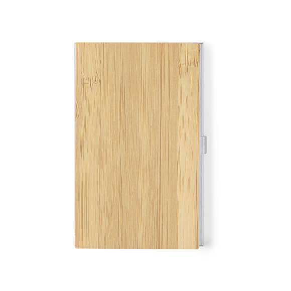 Elegante tarjetero fabricado en suave bambú, con tapas duras y cierre de presión. Destaca el detalle de bambú en la parte frontal y cuenta con un compartimento interior para almacenar tarjetas. Presentado en una bolsa individual de papel reciclado.Materiales como el bambú fomentan la utilización de materias primas naturales, reduciendo las emisiones contaminantes. Proviene de una planta de gran resistencia y versatilidad, con crecimiento y regeneración rápidos, siendo una excelente alternativa al uso de madera tradicional.