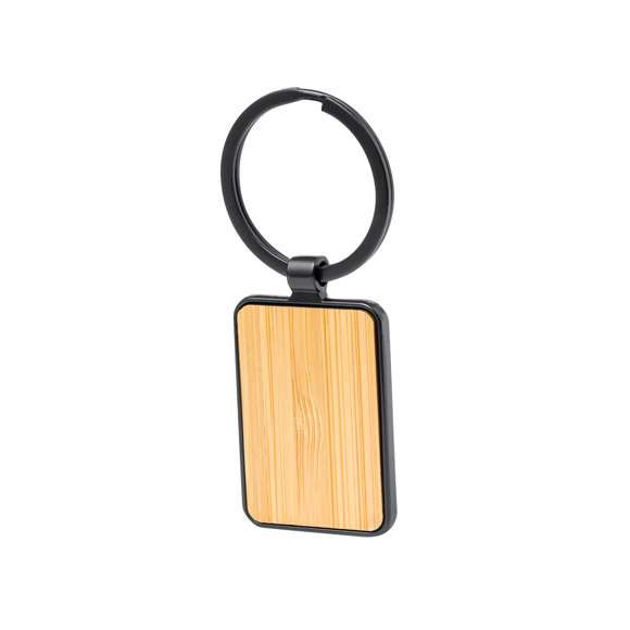 Llavero de elegante diseño, fabricado en metal pulido de color negro, con una cara en suave bambú. Especialmente diseñado par marcaje en láser y disponible en diseño rectangular y circular. Presentado individualmente bolsa de papel reciclado.