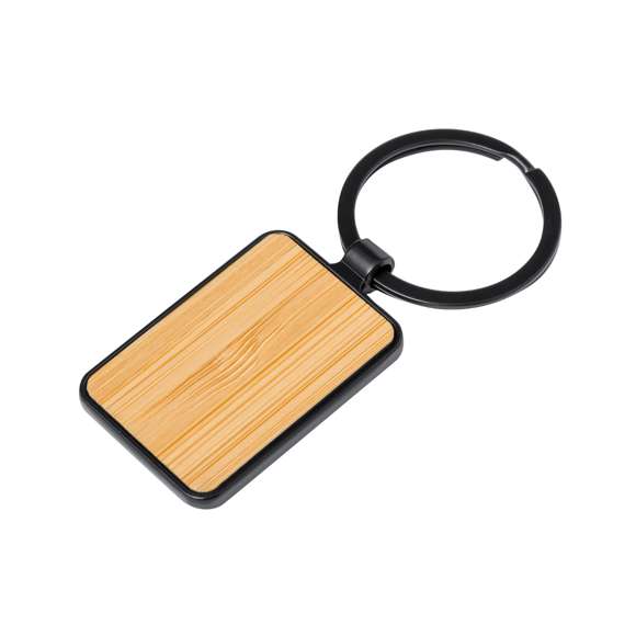 Llavero de elegante diseño, fabricado en metal pulido de color negro, con una cara en suave bambú. Especialmente diseñado par marcaje en láser y disponible en diseño rectangular y circular. Presentado individualmente bolsa de papel reciclado.