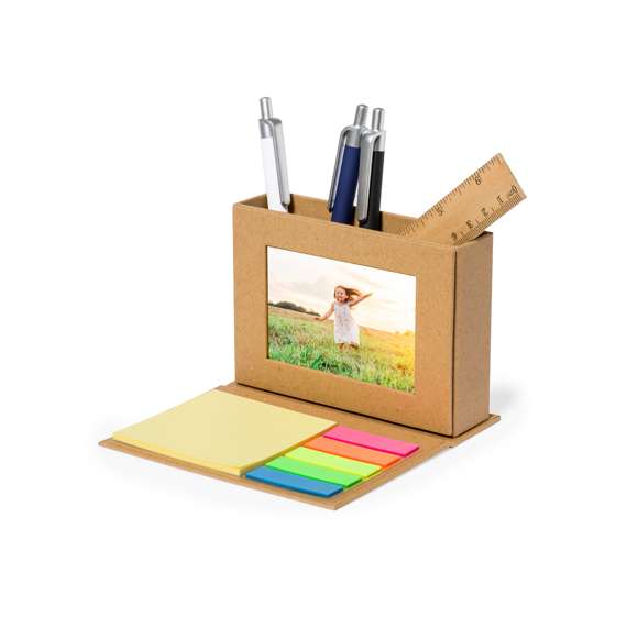 Práctico lapicero multifunción plegable fabricado en cartón reciclado. Incluye soporte para lápices con portafotos de 5x8cm y notas adhesivas: 25 notas de 7,5x7,5cm y 125 mininotas de 1,2x4,5cm en variados colores. Presentado individualmente en una bolsa reciclada.El cartón reciclado proviene del reaprovechamiento de excedente de fabricaciones y reciclaje de papel en el final de su vida útil, convirtiéndose en un lienzo ecológico y sostenible.
