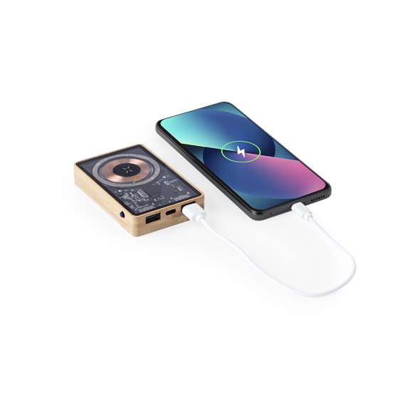 Batería auxiliar externa de original diseño y superficie transparente que permite ver los componentes internos del dispositivo. 5.000 mAh de capacidad de carga, con base en bambú y cargador inalámbrico integrado 15W. Conexiones de entrada/salida Tipo C + salida USB. Fijación magnética Magsafe y compatible con dispositivos equipados con tecnología de carga inalámbrica Qi. Cable de carga incluido, con manual de instrucciones en español e inglés. Presentada en caja individual de diseño eco y en cartón kraft.Entrada/Salida Tipo C: 5-12V DC 3-1.67A, 20WSalida USB: 5-12V DC 3-1.5A, 18WLas capacidades mostradas en todas nuestras baterías auxiliares externas son reales, incorporando todas ellas baterías de grado A y no recicladas, con una vida útil de al menos 500 ciclos de carga y según normativa CE. Además, están fabricadas conforme a los estándares RoHS y en cumplimiento con los siguientes requisitos de seguridad:Sistema de protección contra sobrecarga del power bank.Sistema de protección contra descarga completa que proporciona una mayor durabilidad del power bank.Sistema de bloqueo para evitar cortocircuitos.Sistema de transferencia de carga constante, acorde con la capacidad del dispositivo de destino.Materiales como el bambú fomentan la utilización de materias primas naturales, reduciendo las emisiones contaminantes. Proviene de una planta de gran resistencia y versatilidad, con crecimiento y regeneración rápidos, siendo una excelente alternativa al uso de madera tradicional.