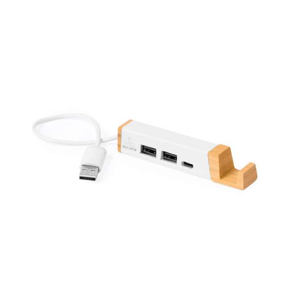 Puerto USB con soporte para smartphone integrado, fabricado en combinación de bambú y material reciclado a partir de cartones de leche. Incluye conexión dual USB/Tipo C y 3 puertos: 1 puerto Tipo C y 2 puertos USB. Con logotipo cartones de leche reciclados y presentado en caja individual de diseño kraft, con papel protector incluido.Los cartones de leche se componen en su mayor parte de cartón y aluminio. Durante su proceso de reciclado, se separan los distintos materiales del envase para su reutilización y nuevo uso, contribuyendo así a recorrer el camino infinito de la economía circular. Este material se caracteriza por su alto grado de reciclabilidad, así como por su ligereza y resistencia.Materiales como el bambú fomentan la utilización de materias primas naturales, reduciendo las emisiones contaminantes. Proviene de una planta de gran resistencia y versatilidad, con crecimiento y regeneración rápidos, siendo una excelente alternativa al uso de madera tradicional.Fabricado conforme a estándares RoHS, con sistema de bloqueo para evitar cortocircuitos.