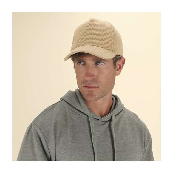 Gorra de 5 paneles fabricada en resistente poliéster efecto pana. Con orificios de ventilación bordados y cierre trasero ajustable de hebilla metálica. Disponible en variada gama de colores.