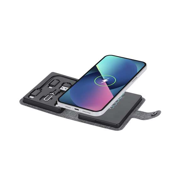 Completa base cargadora fabricada en 300D RPET. Estuche con cierre de corchete incluyendo base cargadora inalámbrica Qi para smartphone, auriculares y smartwatch. Contiene cable de conexión Tipo C en ambos extremos, además de adaptadores USB y lightning/micro USB. El set lo completa un eyector de tarjeta SIM y un compartimento para guardar una tarjeta Micro SIM. Con distintivo RPET.El material RPET se elabora a partir de plástico reciclado, para así fomentar la reutilización de residuos plásticos y ayudar a la sostenibilidad del planeta.