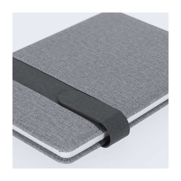 Bloc de notas A5 fabricado en PU. Elegante diseño gris con banda negra de cierre magnético a juego. Interior con 80 hojas color crema de disposición a una raya y marcapáginas de tela a juego.