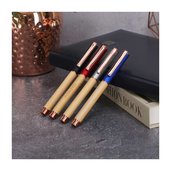 Elegante roller fabricado en bambú y aluminio. Con clip metálico, empuñadora y detalles de acabado oro rosa, caña fabricada en bambú y tapadera en aluminio. Con cartucho jumbo, en tinta azul y con cierre de capucha.