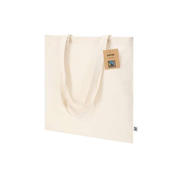 Bolsa confeccionada principalmente en algodón de 140g/m2. Con certificación Fairtrade (Comercio Justo) un sistema comercial solidario y alternativo al convencional que persigue el desarrollo de los pueblos y la lucha contra la pobreza. De acabado cosido, con asas largas de 70cm y resistencia hasta 7kg de peso. Incluida etiqueta Fairtrade y hangtag distintivo en cartón reciclado.
