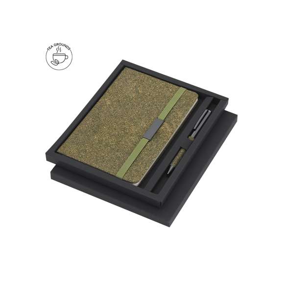 Set de bloc de notas y bolígrafo confeccionados con Fibra de Té. Incluye un bloc de notas de tapas rígidas, con 80 páginas rayas, banda elástica con clip metálico y marcapáginas a juego. Además, cuenta con un bolígrafo de aluminio de acabado cromado con empuñadura de Fibra de Té, mecanismo giratorio y tinta azul. Con logo Tea Grounds marcado en la parte trasera del bloc de notas. Se presenta de manera elegante en una caja negra.Tea Grounds es un material sostenible creado a partir de residuos de hojas de té recicladas. Durante el procesamiento del té, se recolectan y compactan los restos para darles una segunda vida como recurso útil. Su producción fomenta la economía circular y reduce el impacto ambiental.