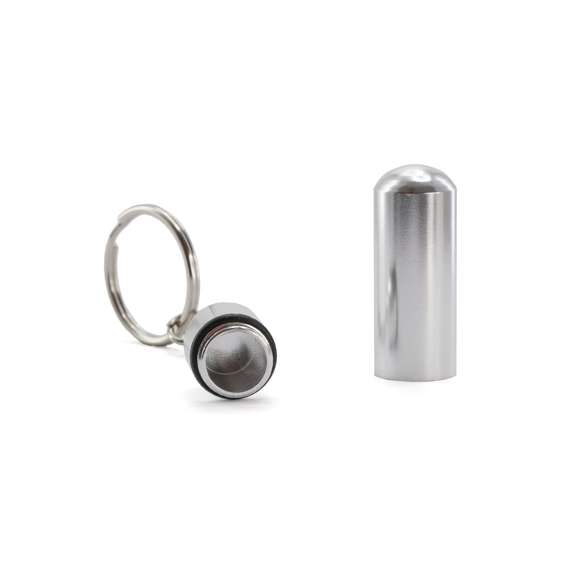 Llavero pastillero de discreto diseño con cuerpo en aluminio de acabado brillante y cierre a rosca.