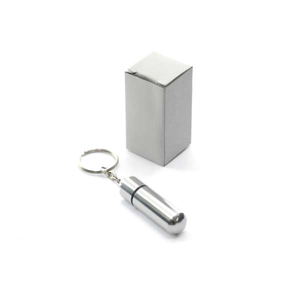 Llavero pastillero de discreto diseño con cuerpo en aluminio de acabado brillante y cierre a rosca.