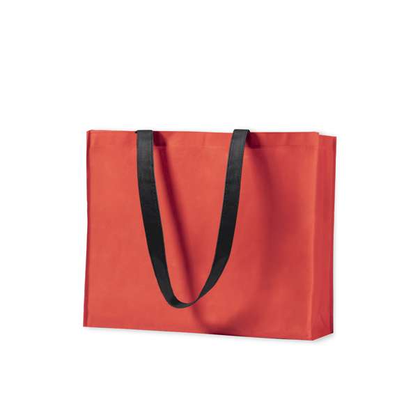 Bolsa en non-woven de 100g/m2, en variada gama de vivos colores. Con asas largas de 70cm en color negro, fuelle reforzado con ribete a juego y acabado cosido.