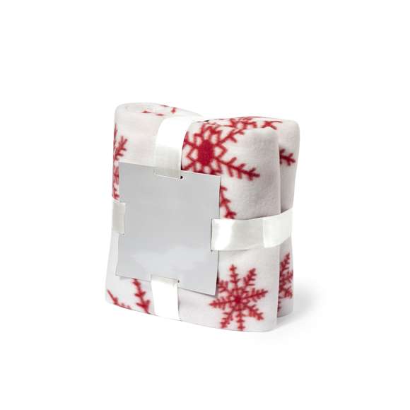 Manta de 130x160cm en original diseño de navidad de color rojo con motivos navideños en blanco. En suave y cálido material polar fleece de 200g/m2 con tratamiento antipilling. Presentada con cartón de color plateado y cinta lazo a juego en suave poliéster.
