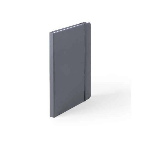 Bloc de notas A5 con tapas duras fabricado en suave polipiel y con 100 hojas lisas. Incluye marcapáginas de tela y banda elástica a juego. Disponible en una extensa gama de colores y presentado en bolsa individual de papel reciclado.