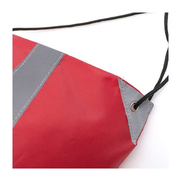 Mochila reflectante en suave poliéster 190T de alegres colores, con tira frontal reflectante. Cuerdas autocierre en color negro y esquinas reflectantes reforzadas con argollas metálicas.