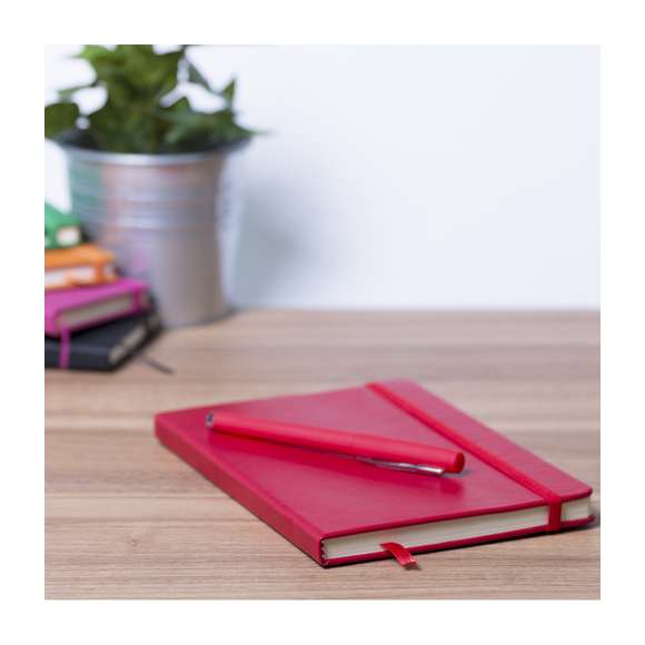 Set de bloc de notas con tapas de suave tacto acabadas en polipiel y bolígrafo de suave cuerpo a juego. De 100 hojas lisas con elástico de sujeción y marcapáginas de tela a juego. Presentado en elegante estuche de cartón blanco troquelado. Bolígrafo en tinta azul.