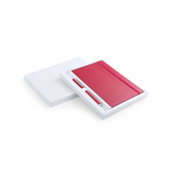 Set de bloc de notas con tapas de suave tacto acabadas en polipiel y bolígrafo de suave cuerpo a juego. De 100 hojas lisas con elástico de sujeción y marcapáginas de tela a juego. Presentado en elegante estuche de cartón blanco troquelado. Bolígrafo en tinta azul.