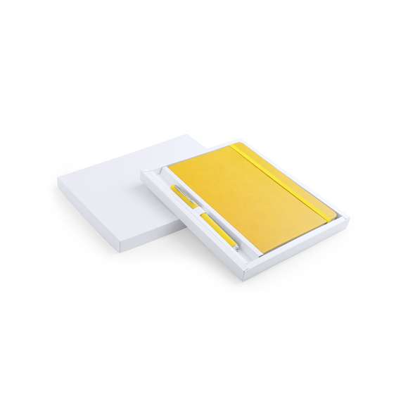 Set de bloc de notas con tapas de suave tacto acabadas en polipiel y bolígrafo de suave cuerpo a juego. De 100 hojas lisas con elástico de sujeción y marcapáginas de tela a juego. Presentado en elegante estuche de cartón blanco troquelado. Bolígrafo en tinta azul.