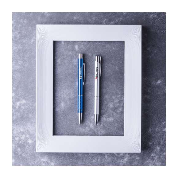 Original bolígrafo de mecanismo pulsador en elegante diseño bicolor. Con cuerpo troquelado en aluminio de suave acabado en variados colores. Original clip, anillas y punta en plateado. De cartucho jumbo y tinta azul.