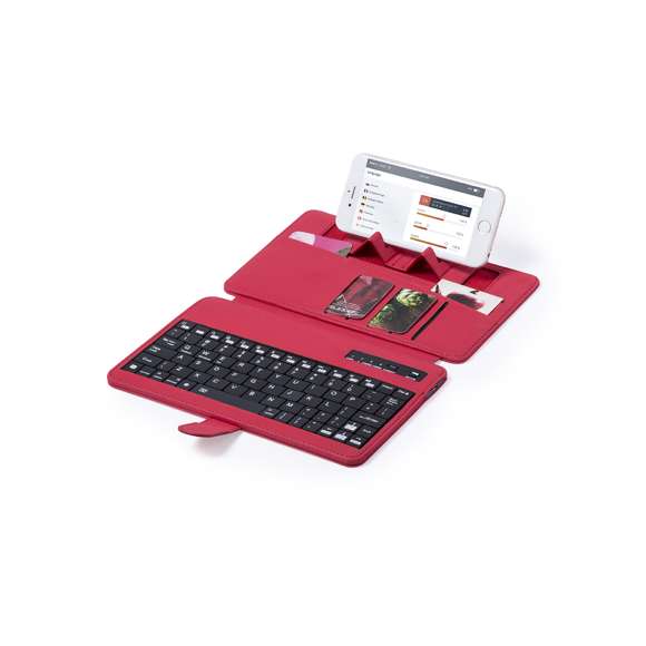Teclado soporte Bluetooth® con función soporte para dispositivo móvil en suave acabado de polipiel. De diseño compacto, con solapa de cierre magnético, tarjeteros interiores, en atrevidos colores y recargable mediante cable mini USB -incluido-. Compatible con cualquier sistema operativo y presentado en atractiva caja de diseño.