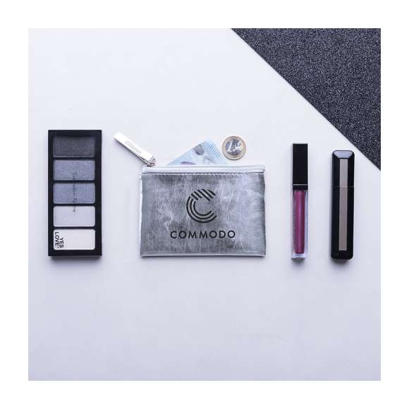 Monedero de diseño super cuqui con suave cuerpo acabado en brillante polipiel. Disponible en colores dorado, plateado y oro rosa. Compartimento principal con cierre de cremallera y tirador a juego.