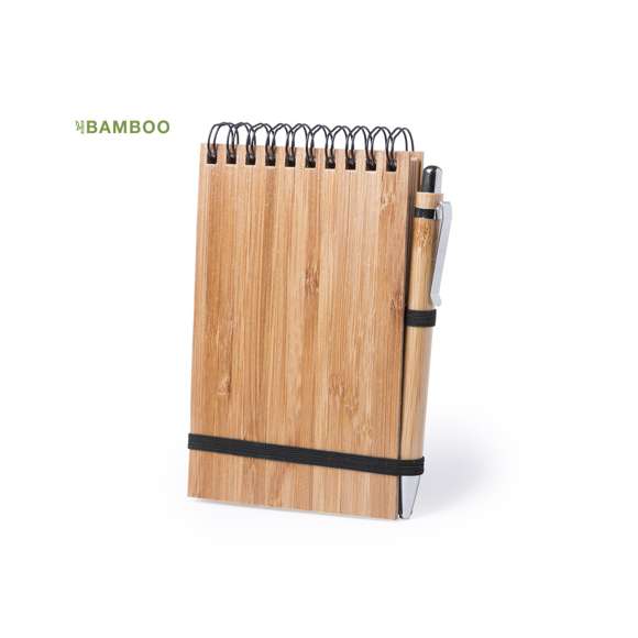  	Libreta de anillas en línea nature con tapas rígidas de bambú y bolígrafo a juego, también en bambú. De tamaño compacto, con elástico de cierre en elegante color negro. Incluye 70 hojas con disposición a una raya y diseño eco. Bolígrafo con cartucho jumbo y tinta azul.