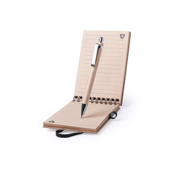  	Libreta de anillas en línea nature con tapas rígidas de bambú y bolígrafo a juego, también en bambú. De tamaño compacto, con elástico de cierre en elegante color negro. Incluye 70 hojas con disposición a una raya y diseño eco. Bolígrafo con cartucho jumbo y tinta azul.